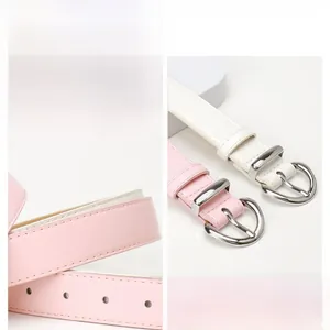 Detail of pink and white PU leather belts featuring round silver metal buckles