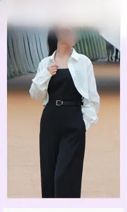 Gros plan d'une ceinture fine en cuir noir avec boucle dorée sur chemise et combinaison