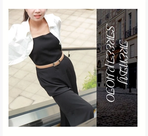 Détail d'une fine ceinture en cuir marron portée avec un pantalon large noir chic