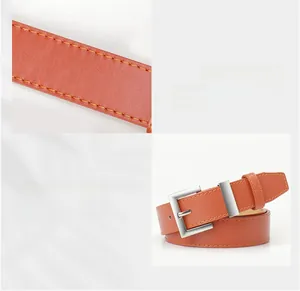 Detail eines orangebraunen Ledergürtels mit silberner Legierungsschnalle und Ziernaht