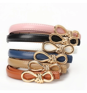 Detailed set of women's skinny leather belts with elegant golden bow-shaped metal buckles