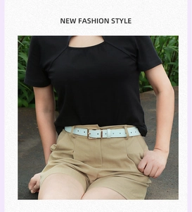 Détail d'une fine ceinture bleu clair avec boucle dorée sur un short kaki femme