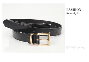 Gros plan d'une ceinture noire en similicuir avec boucle rectangulaire dorée polie