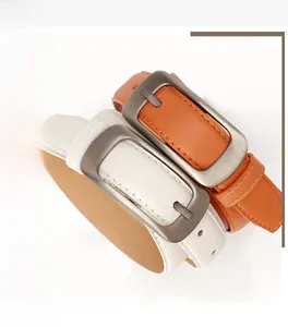 Détail de fines ceintures en similicuir orange-brun et blanc avec boucle en métal