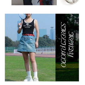 Close-up of a slim red leather belt paired with a denim skirt and sporty graphic tank top