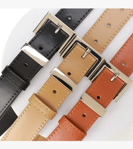Detailansicht von Ledergürteln in Schwarz, Khaki und Braun mit silbernen Metallschnallen