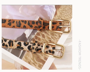 Gros plan sur les ceintures fines imprimé léopard en caramel et beige avec boucles