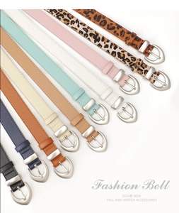Flat lay of colorful thin PU leather belts featuring silver heart-shaped pin buckles
