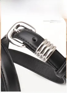 Detailopname van zwarte imitatieleren riem met zilveren gesp en decoratieve metalen ringen
