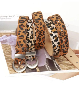 Detail of leopard print PU leather belts with silver matte metal buckles on magazine