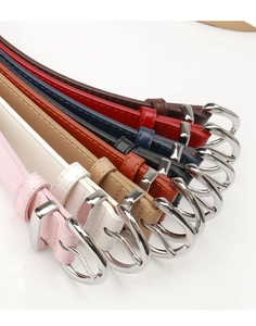 Detailed macro view of eight colorful slim faux leather belts with silver metal buckles