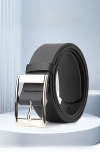 Close-up of black PU leather belt with silver square buckle on a minimalist pedestal