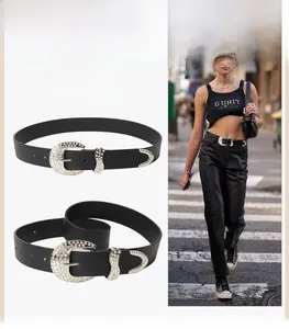 Close-up of black western belt featuring sparkling rhinestone buckle and metal tip set