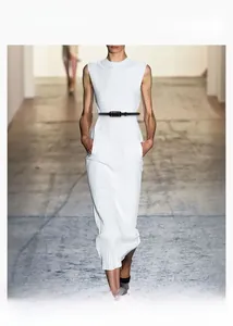 Detail of a slim black leather belt with a metal buckle on a white knitted dress