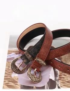 Detail of vintage embossed alloy buckle and textured leather belts for women