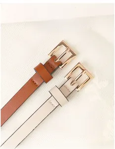 Close-up of brown and cream PU leather belts with polished gold alloy square buckles