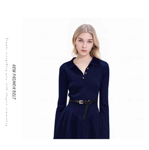Detail view of a slim black PU leather belt with a square gold buckle on a navy blue dress