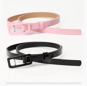 Detail of slim patent leather belts with matching rectangular buckles in pink and black