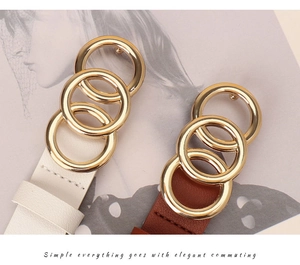 Close-up of three-ring interlocking gold buckle and textured leather belts