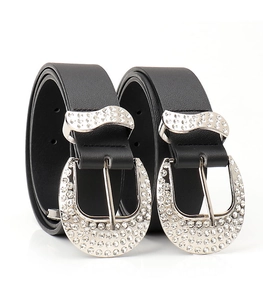 Close-up of black leather belts with sparkling rhinestone buckles and western style