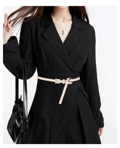 Detail of a slim cream PU leather belt with a square buckle on a black blazer