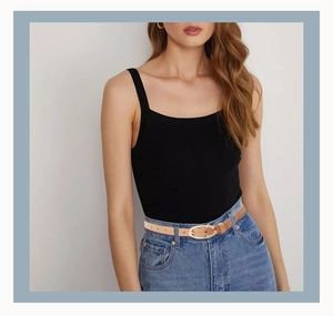 Fine ceinture en similicuir camel avec boucle dorée sur un jean bleu pour femme