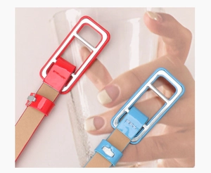 Close-up of bright red and light blue patent leather skinny belts with silver H buckles