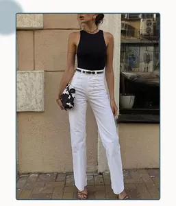 Détail d'une fine ceinture noire à boucle dorée sur un jean blanc à taille haute