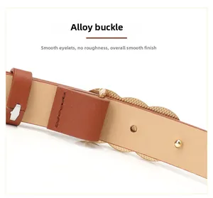 Close-up of brown leather belt with matte gold alloy snap buckle and metal reinforced eyelets