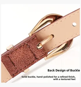 Macro shot of handcrafted solid gold buckle on brown leather belt with refined stitching