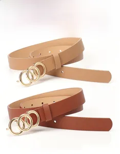 Detail of camel and brown leather belts featuring stylish golden triple-ring buckle design