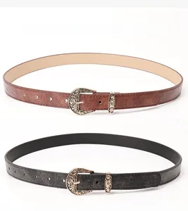 Detail of vintage fashion belts featuring engraved metal buckles in black and brown leather