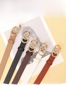 Detail view of thin women's belts in five colors with golden three-ring buckles
