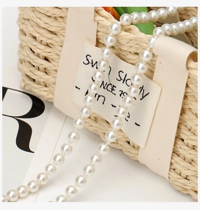 Detail shot of lustrous white pearls on a stylish long chain for dresses and accessories