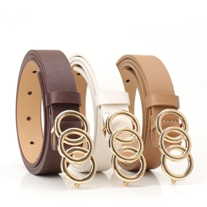 Close-up of three fashion belts in brown, white and khaki with triple ring gold buckles