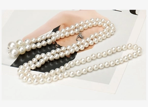 Detail of multi-layered pearl chain with silver lobster clasp on a fashion magazine