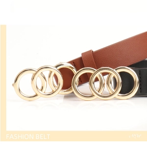 Detail of black and brown fashion belts featuring polished golden double ring buckles