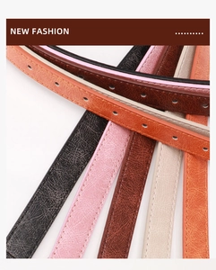 Close-up of slim cracked leather belts in multi-colors with fine stitching and holes