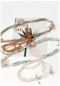 Détail de la ceinture en corde de cire tressée avec pendentifs papillon et perles turquoise