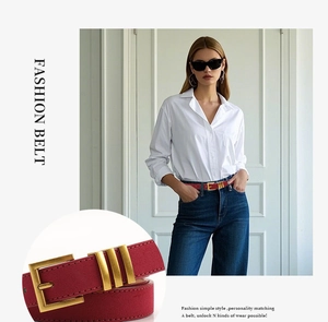 Détail d'une ceinture en daim bordeaux avec boucle dorée vintage sur un jean denim
