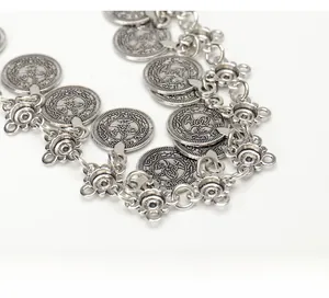 Dettaglio catena in vita retrò argento con ciondoli a moneta e maglie a fiore