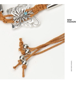 Détail de la ceinture bohème tressée avec boucle papillon argentée et incrustation