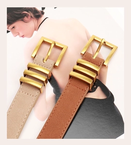 Détail des ceintures en daim beige et marron avec boucles carrées en métal doré