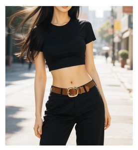 Close-up of a stylish wide brown leather belt with a large gold square buckle on jeans