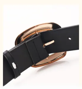 Detailed macro view of the back of a gold rectangular buckle on a black leather belt