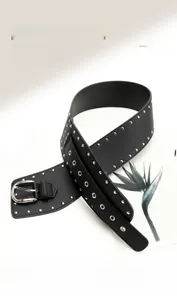 Détail d'une large ceinture corset en cuir PU noir avec rivets argentés et boucle