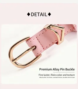 Dettaglio della cintura in pelle rosa con fibbia dorata e decorazione in metallo a V