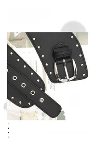 Détail d'une ceinture punk large noire avec rivets argentés et boucle ardillon classique