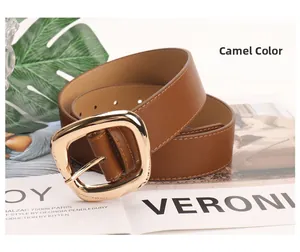 Detail of camel leather belt featuring a large gold square buckle and fine stitching