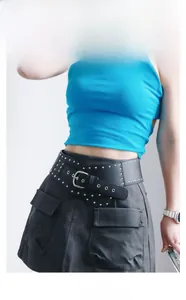 Détail d'une large ceinture punk noire en cuir PU avec rivets et boucle ovale argent